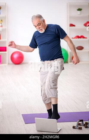 L'uomo anziano fa esercizi sportivi a casa Foto Stock