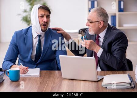 Giovane impiegato d'affari che soffre di mal di denti in ufficio Foto Stock