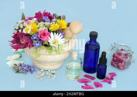 Erbe curative e fiori per rimedi alternativi di medicina delle piante di erbe con bottiglie di olio essenziale di aromaterapia. Natura salute e benessere concetto. Foto Stock