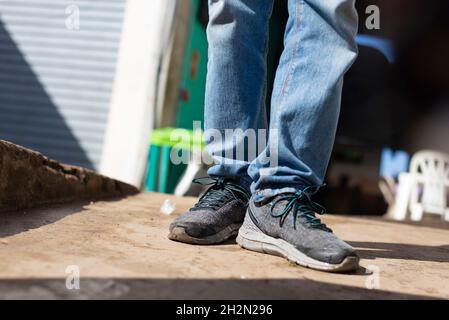 Scarpe e pantaloni di una persona che si trova di fronte all'ingresso della fiera di Sao Joaquim. Salvador Bahia Brasile. Foto Stock