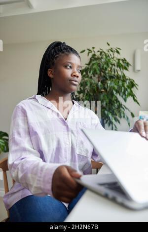 Ragazza infelice teenage che chiude il coperchio del computer portatile dopo abuso in linea e bullismo sui social media Foto Stock