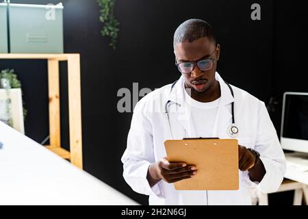 Sorridente operatore sanitario maschile con smartphone in clinica medica Foto Stock