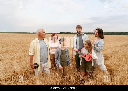 Uomo anziano sorridente che tiene la macchina fotografica in campo agricolo Foto Stock