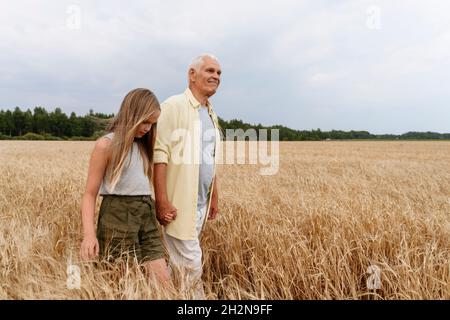 Ragazza bionda che fotografa attraverso la macchina fotografica sul campo di grano Foto Stock