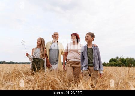 Nipote fotografa i nonni attraverso la macchina fotografica in campo di grano Foto Stock
