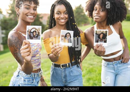 Giovane donna che prende selfie con le amiche mentre si sdraia sull'erba Foto Stock