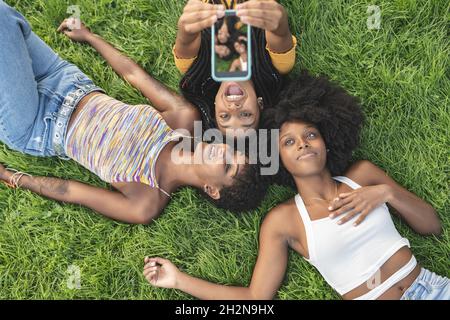 Giovani amiche giacciono sull'erba Foto Stock