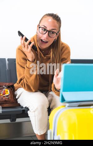 Donna sorridente con borsa seduta su panca Foto Stock