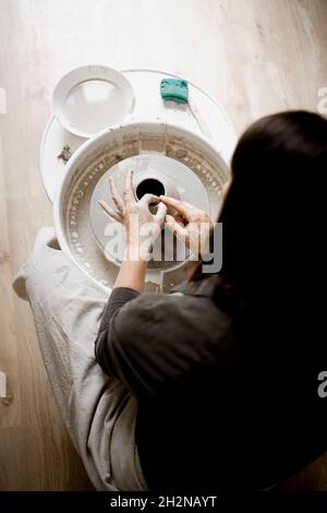 Craftswoman che lavora sulla ceramica in officina Foto Stock