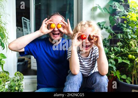 Uomo che tiene ciotola di pomodori freschi in orto Foto Stock