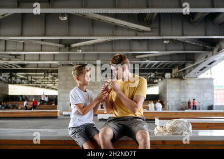 Uomo anziano sorridente che tiene mirtilli nella foresta Foto Stock