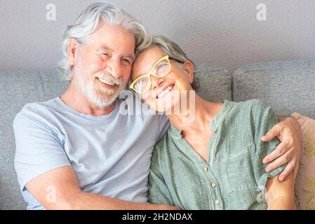 Senior sorridente giovane seduto sul divano nel soggiorno Foto Stock