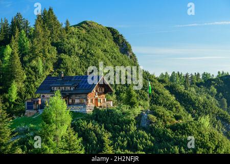 Idilliaco scatto di casa sulla montagna verde contro il cielo Foto Stock