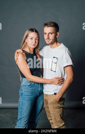 Giovane coppia che si abbraccia mentre si alza in studio Foto Stock
