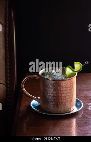 Cocktail Mule di Mosca con ghiaccio schiacciato e lime in Copper Mug nel lussuoso Bar Dark Foto Stock