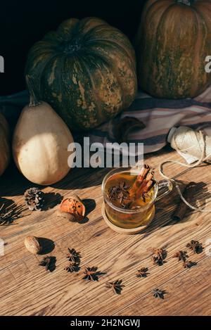 Zucche e bicchiere di tè caldo con cannella e anice stellato Foto Stock