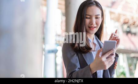 Concetto di donna di lavoro una donna d'affari che ha la videoconferenza con il cliente fuori dell'ufficio. Foto Stock