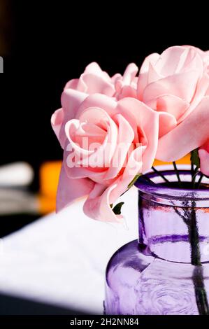 fiori rosa in vaso su un tavolo Foto Stock