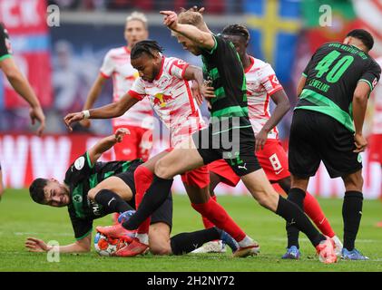 23 ottobre 2021, Sassonia, Lipsia: Calcio: Bundesliga, giorno 9: RB Leipzig - SpVgg Greuther Fürth alla Red Bull Arena. I giocatori di Fürth Maximilian Bauer (a terra), Sebastian Griesbeck (M) e Jamie Leweling (r) lottano per la palla con Christopher Nkunku (l) e Amadou Haidara (r) di Lipsia. Foto: Jan Woitas/dpa-Zentralbild/dpa - NOTA IMPORTANTE: In conformità con le norme della DFL Deutsche Fußball Liga e/o della DFB Deutscher Fußball-Bund, è vietato utilizzare o utilizzare fotografie scattate nello stadio e/o della partita sotto forma di immagini sequenziali e/o video-li Foto Stock