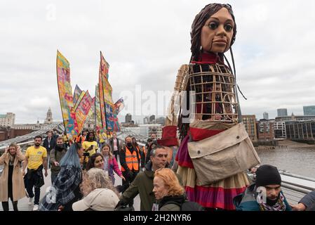 23/10/2021. Londra, Regno Unito. Little Amal, il marionello alto 3.5 metri di una ragazza siriana immigrata di nove anni, attraversa Millennium Bridge. Il burattino gigante ha quasi completato un viaggio di 5,000 miglia attraverso l'Europa, con l'obiettivo di portare l'attenzione dei giovani rifugiati e i viaggi per una vita migliore. Foto di Ray Tang. Foto Stock