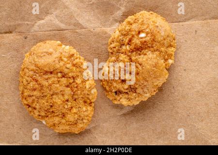Deliziosi fiocchi multigrain su carta marrone, primo piano, vista dall'alto. Foto Stock