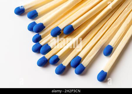 Il legno blu si adatta a uno sfondo grigio chiaro. Fiammiferi con teste macro blu brillante. Partite di legno sparse senza box closeup. Elemento di progettazione Foto Stock