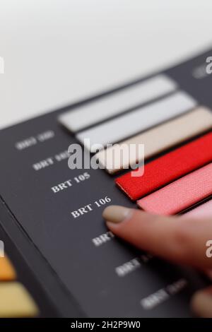 Mano femminile scelta del colore giusto dal catalogo, primo piano Foto Stock