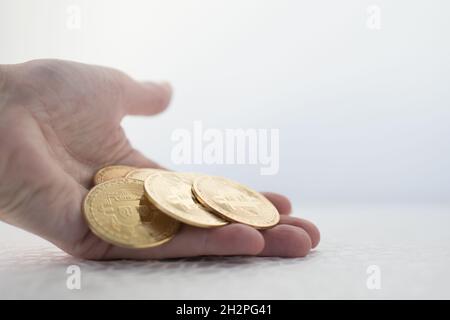 Bella mano di una donna con molti bitcoins. Sfondo bianco Foto Stock