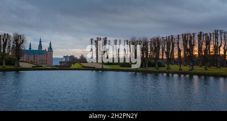 Frederiksborg castello al tramonto, con lago e albero in primo piano, Hillerod, Danimarca Foto Stock