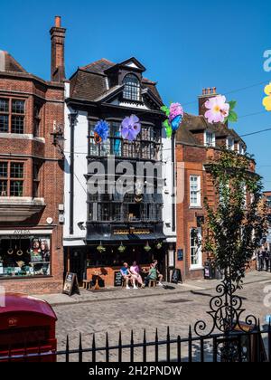 Guildford High Street con colorati striscioni autunnali, telefono rosso tradizionale e storico tre pidoggeons casa pubblica dietro con alfresco bevitori Guildford Surrey UK Foto Stock