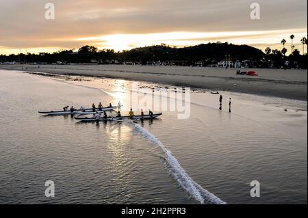 Due squadre di canoa si dirigono verso il mare a Santa Barbara, California Foto Stock