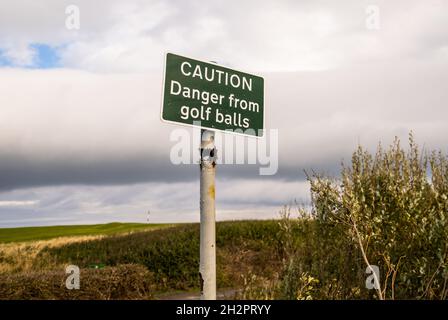 Segno di attenzione per "pericolo da palline da golf" sul sentiero costiero di Cleveland a Whitby, North Yorkshire Foto Stock