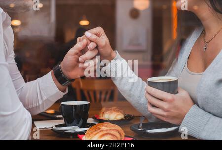 datazione, appuntamento romantico in ristorante per coppia, uomo e donna tenendo le mani Foto Stock