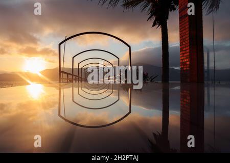 Tramonto sul molo con una superficie a specchio. Foto Stock