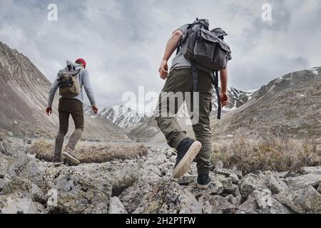 Due giovani escursionisti o turisti con piccoli zaini passeggiate in montagna. Concetto di turismo attivo Foto Stock