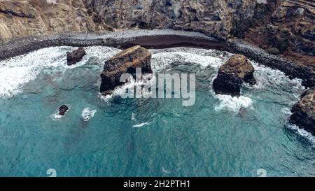 Vista aerea dell'ondeggiante oceano Atlantico settentrionale che colpisce le scogliere rocciose dell'isola di Tenerife in Spagna Foto Stock