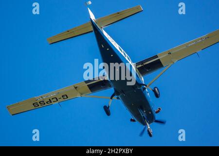 cosse up di Cessna 208b Grand Caravan G-CPSS aereo leggero vola basso sopra la testa subito dopo il decollo con paracadutisti a bordo Foto Stock