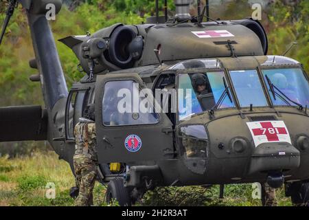 Hawaii Army National Guard (HIARNG) Soldates Sgt. Brooke McKenzie (a sinistra), un capo dell'equipaggio di Black Hawk UH-60, Chief Warrant Officer 3 Hau Okada (al centro), un pilota di Black Hawk da 60M e Chief Warrant Officer 3 Kaniauokahekili Kaaa (a destra), un pilota dell'istruttore UH-60M, tutti con distacco 1, Golf Company, terzo battaglione, 126th Aviation Regiment condurre procedure di avvio per il UH-60M Black Hawk aereo dopo aver ricevuto una chiamata per l'evacuazione medica (MEDEVAC) durante l'addestramento del paranco elicottero, Wahiawa, Hawaii, 17 giugno 2021. La formazione operativa come questa aiuta i soldati a certificare il loro sci speciale Foto Stock