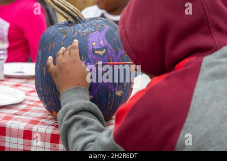 Detroit, Michigan, Stati Uniti. 23 ottobre 2021. Ottobre Fest nel quartiere Morningside ha offerto pittura di zucca e altre attività per i bambini. Credit: Jim West/Alamy Live News Foto Stock