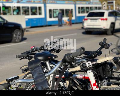 Parcheggio in bicicletta nel centro città. Sullo sfondo c'è traffico occupato di automobili e tram. Foto Stock