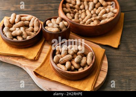 Immagine di un mazzo di arachidi in una ciotola su un tavolo di legno Foto Stock