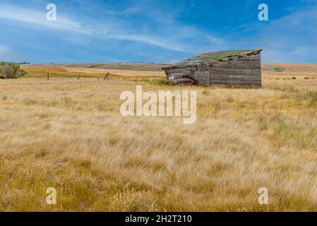 Garage abbandonato e veicolo in un casolare abbandonato sulle praterie di Saskatchewan Foto Stock