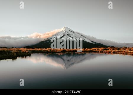 Dopo un'escursione di due ore nel bush della Nuova Zelanda vediamo un incredibile tramonto intorno al Monte Taranaki. Foto Stock