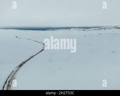 Una vista aerea di un campo nevoso contro un cielo grigio Foto Stock