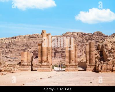 Vista con la strada colonnata e la porta di Temenos nell'antica città di Petra, Giordania. Strada facciata strada strada ciottoli a Petra. Foto Stock