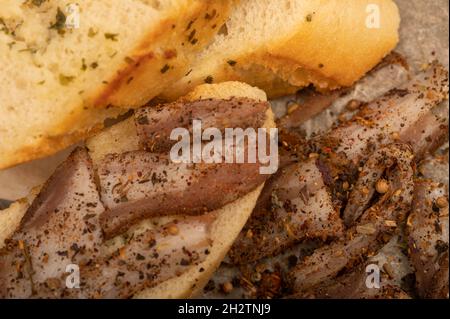 Pancetta fatta in casa tagliata a fette con pepe e pane affettato, primo piano, fuoco selettivo Foto Stock