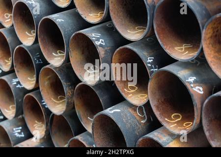 I tubi Maetallici dello stesso diametro sono impilati in modo ordinato. Vista dei tubi dalla parte anteriore. Contesto per il fornitore di prodotti metallici. Foto Stock