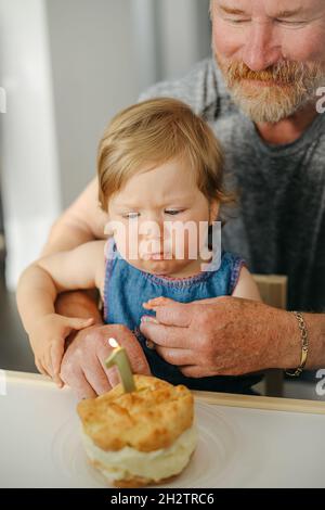 bambino che ha il suo primo compleanno a casa con torta di compleanno Foto Stock