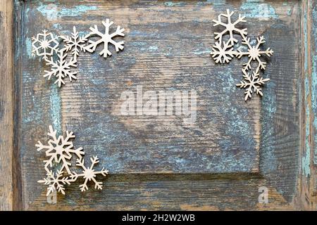 Decorazione di Natale, giocattoli di Capodanno. Fiocchi di neve di legno disposti su una vecchia superficie di legno. Vista dall'alto. Messa a fuoco selettiva. Spazio di copia. Foto Stock