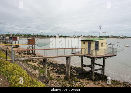 Capanne e reti da pesca lungo tutta la riva a St Nazaire, Francia Foto Stock